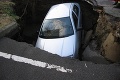 To je ale výtlk: Auto sa prepadlo do diery v ceste!