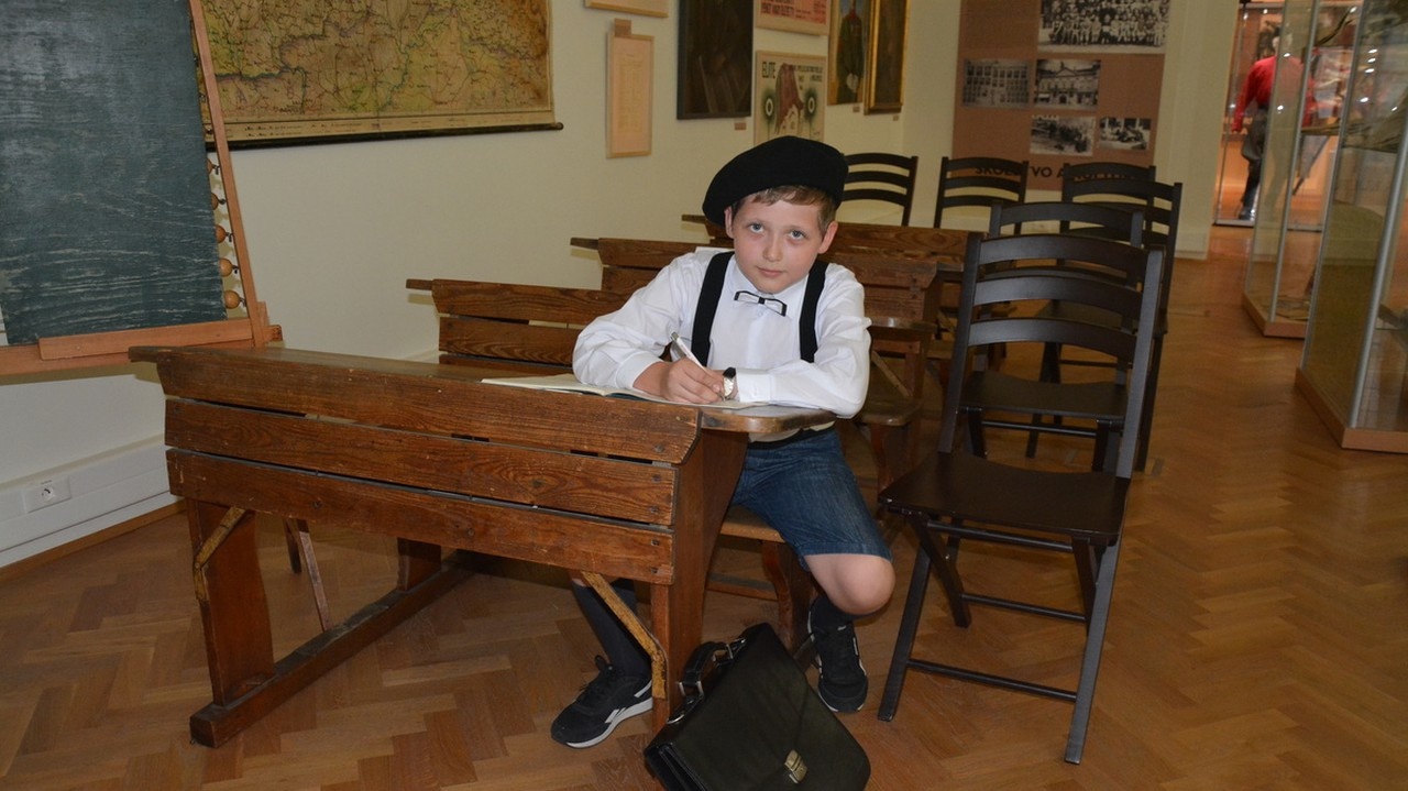 9-ročný Vojtech Karpáty stelesňuje žiaka v rovnošate z roku 1928.
