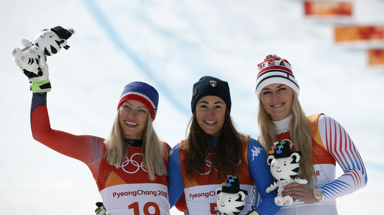 Talianka Sogia Googiová (v strede) oslavuje zlatú madailu v v zjazde žien v stredisku Čongson na XXIII. ZOH v Pjongčangu 21. februára 2018. Striebro získala Nórka Ragnhild Mowinckelová (vľavo) a bronz Američanka Lindsey Vonnová (vpravo).