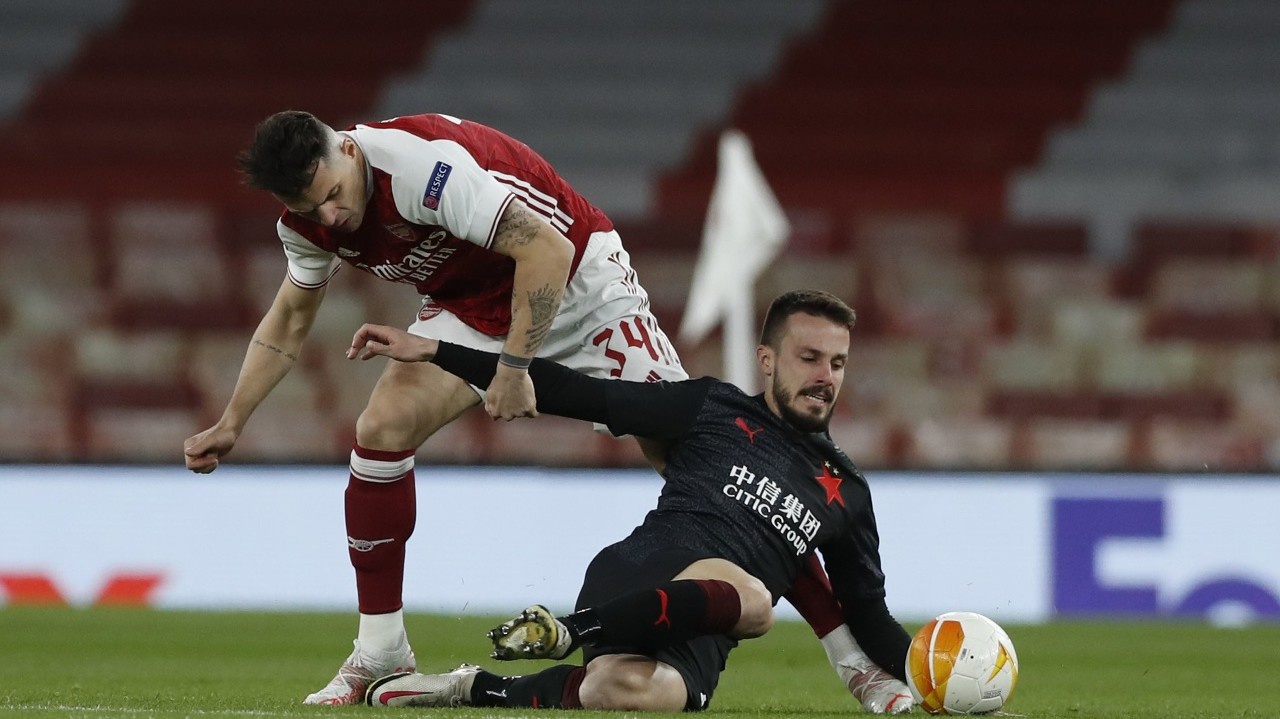 Hráč Arsenalu Granit Xhaka (vľavo) zastavuje Slováka Jakuba Hromadu zo Slavie Praha v zápase štvrťfinále Európskej ligy Arsenal Londýn - Slavia Praha v Londýne 8. apríla 2021.