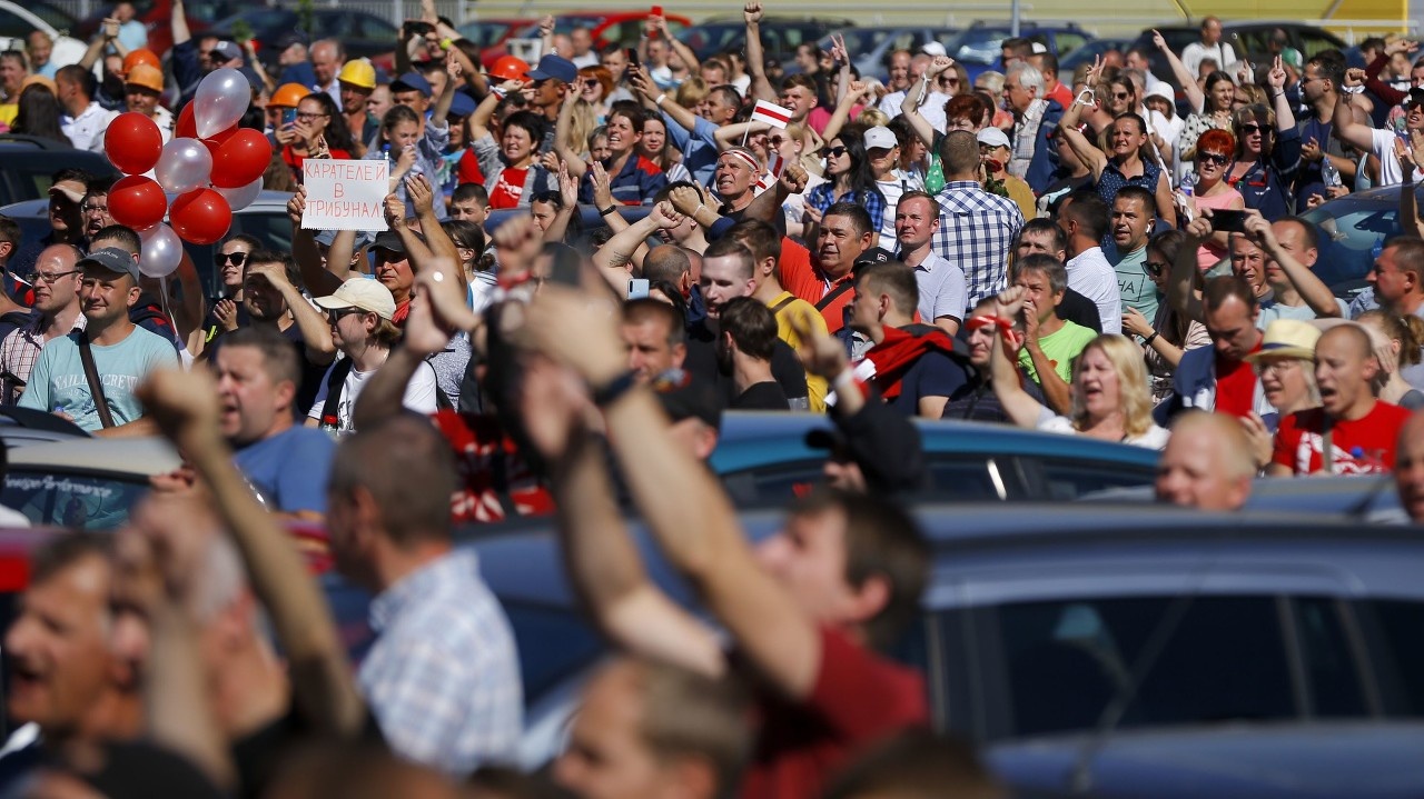 Ľudia protestujú pred továrňou na výrobu ťahačov MZKT v bieloruskom hlavnom meste Minsk.