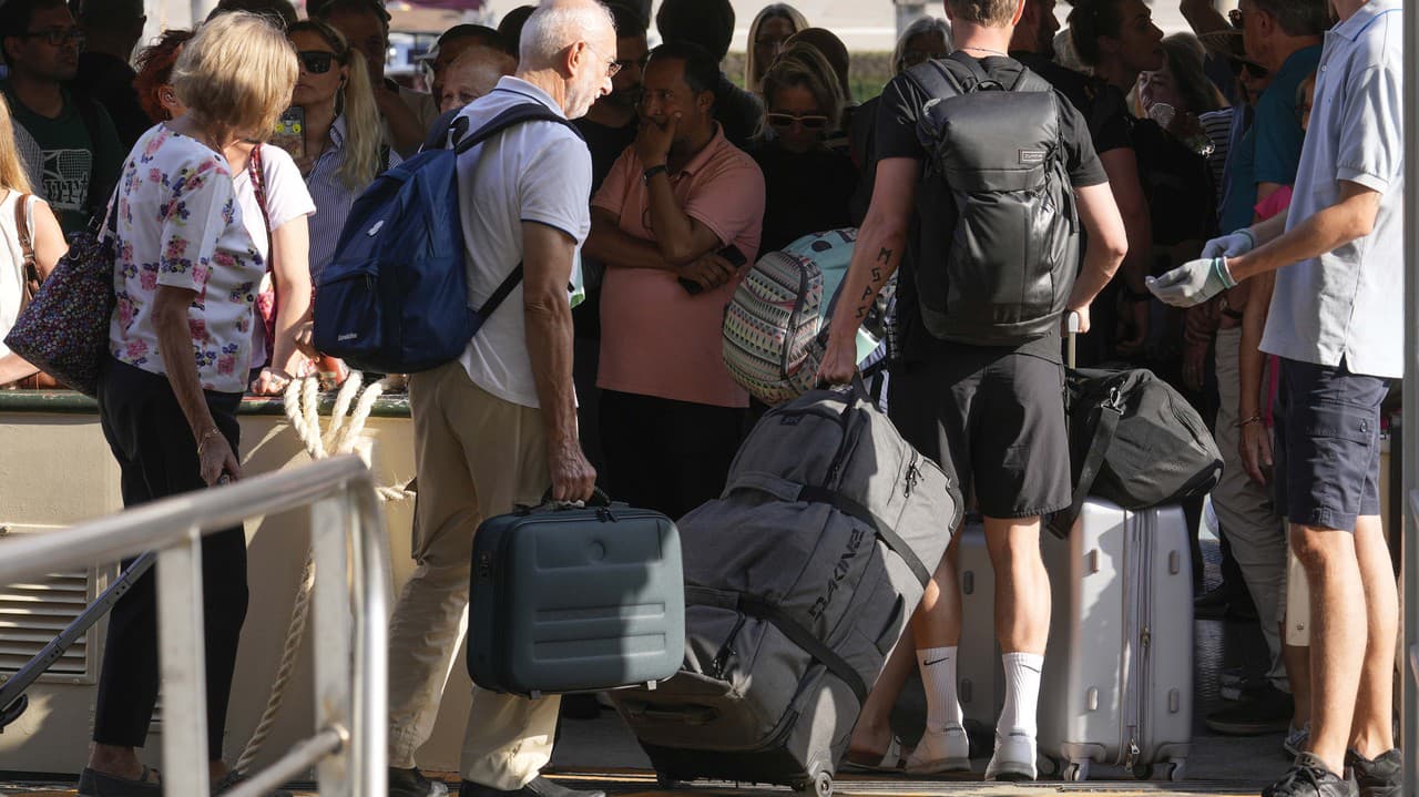 Turisti s batožinou nastupujú na preplnenú loď v talianskom meste Benátky.