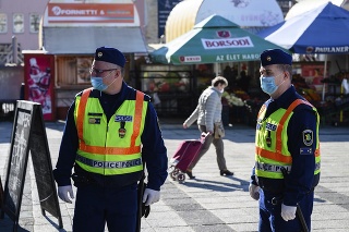 Policajti hliadkujú na uliciachj počas obmedzenia pohybu v dôsledku koronavírusovej pandémie.
