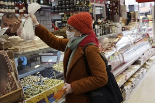Žena s ochranným rúškom na tvári nakupuje v obchode s delikatesami v Ankare.