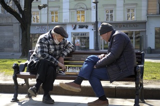 Dvaja ukrajinskí muži hrajú šach na lavičke v meste Lviv.