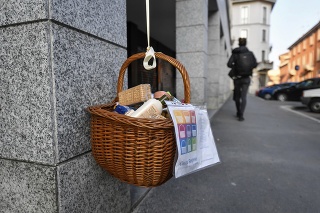 Košík s jedlom a ďalším tovarom visí z balkóna pre tých, ktorí sú v núdzi počas koronavírusovej pandémie v Miláne.