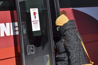 Cestujúca nastupuje s rúškom do prímestského autobusu na autobusovej stanici v Bratislave.