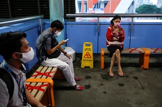 Cestujúci s ochrannými rúškami na vlakovej stanici v Jakarte