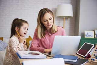 Young mother working from home with daughter
