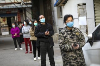 Ľudia v Číne čakajú s rozostupom v rade na bravčové mäso.