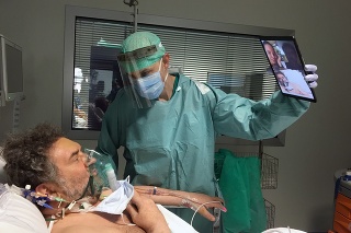 Doktor Matteo Flippini drží tablet pre svojho pacienta Alessandra Mattinzoliho aby sa porozprával so svojimi príbuznými.