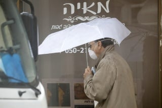 Muž s ochranným rúškom v uliciach izraelského mesta Hadera