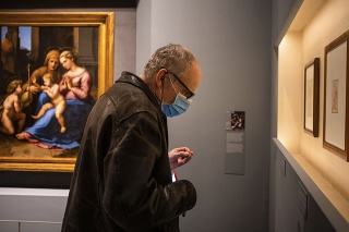 Muž s ochranným rúškom na výstave Raffaela v Ríme.