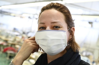 Zamestnankyňa textilnej fabriky Zornica testuje jeden z prvých kusov rúšok.