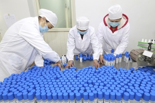 Zdravotníci pri príprave fľašiek s dezinfekciou.