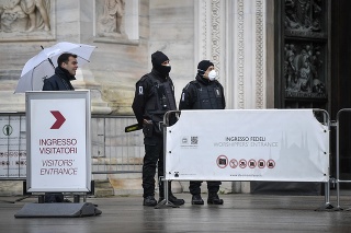 Personál, ktorý vykonáva obliadky, s ochrannými maskami na tvári pred vstupom do milánskej katedrály Duomo 