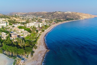 Aerial bird's eye view of Pissouri bay, a village settlement between Limassol and Paphos in Cyprus. Panoramic view of the coast, beach, hotel, resort, hills, plain and building developments from above