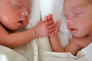Photo of my premature twin girls born eight weeks earlier. Their height is 42 cm, weight - 1.7 kg. They are holding hands.