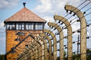 Auschwitz - Birkenau, Poland - August 11, 2019:The guard's watch tower and fence of barbed wire, Auschwitz - Birkenau concentration camp, Poland