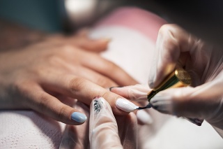 Nails care for women. Close up of beautiful female hands having manicure treatment. Nail polishing.