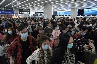 Cestujúci s ochrannými rúškami na letisku v Hongkongu