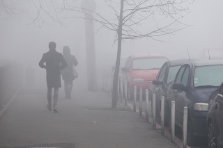 People walk in heavy fog at dawn