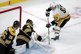 Slovenský brankár Bostonu Bruins Jaroslav Halák (uprostred) chytá streľu kapitána Pittsburghu Penguins Sidneyho Crosbyho.