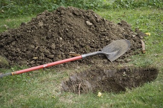 Pile of dirt, shovel and a hole