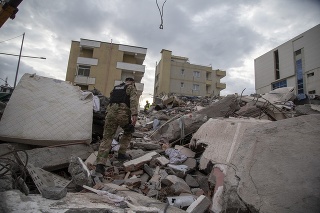 Člen špeciálnej jednotky albánskej polície prechádza sutinami zničenej budovy v meste Durres.