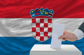 man putting ballot in a box during elections in croatia