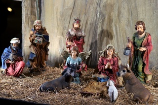 New born Jesus lying in crib or manger in the barn. Figurines of virgin Mary and saint Joseph in the stable. Nativity scene of Holy family. Christmas celebration