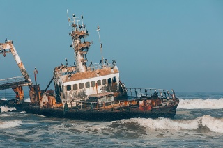 Abandoned and derelict old shipwreck Zeila at the Atlantic Coast near Swakopmund and Henties Bay, famous Skeleton Coast in Namibia, Africa. Group of cormorants birds perching on rusted ship.