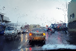 Traffic on a rainy day at dusk, seen through a wet windshield.