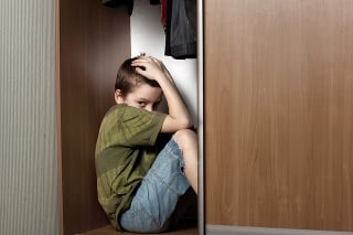 Sad boy, hiding in the closet at home