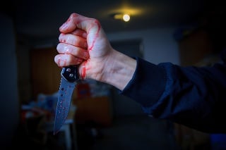 bloody hand holding a knife