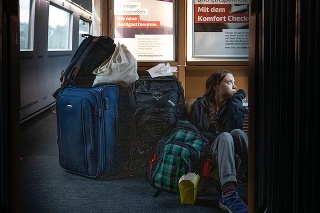 Greta sedí na zemi v preplnenom vlaku.