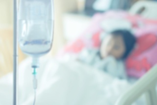 patient on bed at saline solution at hospital blurry background