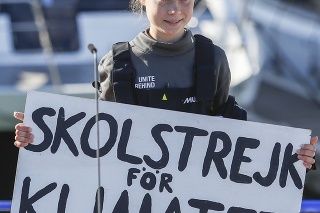 Greta Thunbergová drží trasparent po priplavení sa na katamarane La Vagabonde.