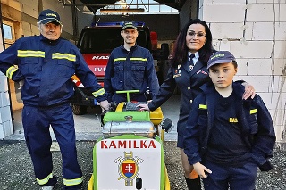 Rodina pri striekačke v hasičskej zbrojnici.