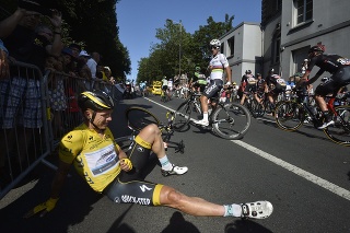 Nemecký cyklista Tony Martin v žltom drese vedúceho pretekára sedí na ceste po hromadnom páde.
