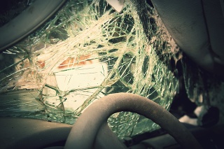 Close op of the steering wheel and shatterd windshield of a wrecked vehicle.  Cross processing.
