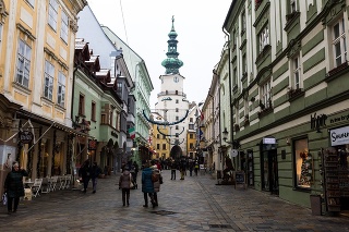 Bratislava, Slovakia - 2 December, 2018: color image depicting the quaint and narrow streets and architecture of old town Bratislava, Slovakia. Locals and tourists walk down the cobblestone street, browsing the shops just before Christmas.