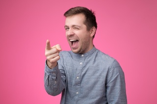 Hey you concept. Happy man pointing on you. Studio shot on pink background.
