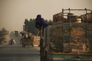 Sýrčania utekajú pred tureckou paľbou z mesta Rás al-Ajn na severe Sýrie.