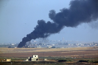 Na snímke z tureckej strany turecko-sýrskej hranice pri meste Akcakale stúpa dym po výbuchoch na sýrskom území.