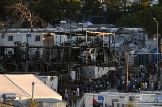 Policajti strážila spálené domové kontajnery v utečeneckom tábore Moria.