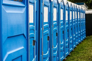 Row of blue chemical and portable toilets for an outdoor party