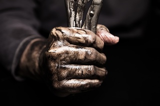 Mechanic holding a wrench in his dirty hands