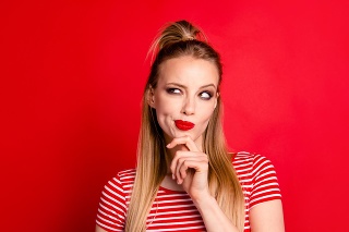 Close-up portrait of nice shine cute funny adorable charming attractive girl wearing striped top touching chin looking aside isolated over bright vivid red background