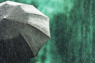 Open black umbrella in wet weather. Autumn rain. Deep sorrow. Wet umbrella against backdrop of street. Sad mood. Raining in city. Heavy rain on summer green background. Feel sorrow and sadness